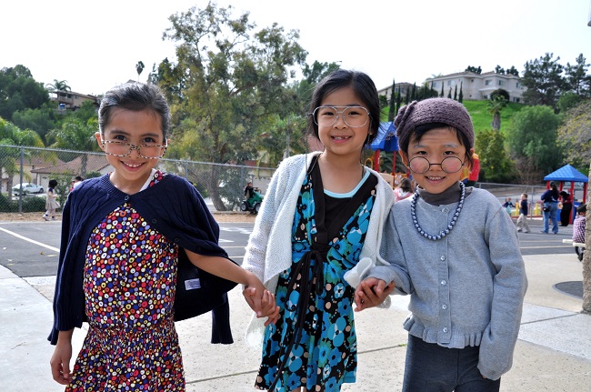 Kindergarteners Rachel Peiten, Chloe Thi, and Molly Chung showed off their 100-year-old costumes.