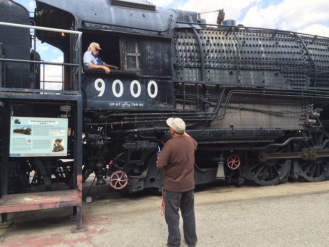 Sam Calderwood, in the cab of the Union Pacific 9000, chats with a patron of the Rail Giants train museum. (Photo by David Allen)