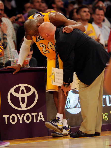 Lakers' Athletic trainer Gary Vitti looks Kobe Bryant #24 after he hurt his ankle during their game against the Warriors at the Staples Center in Los Angeles Friday, April 12, 2013. The Lakers beat the Warriors 118-116. (Hans Gutknecht/Staff Photographer)