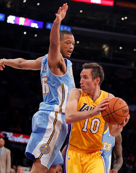 Los Angeles Lakers guard Steve Nash (10) looks to make a pass with Denver Nuggets forward Anthony Randolph defending during an NBA preseason basketball game Sunday, Oct. 6, 2013 in Los Angeles. (AP Photo/Alex Gallardo)
