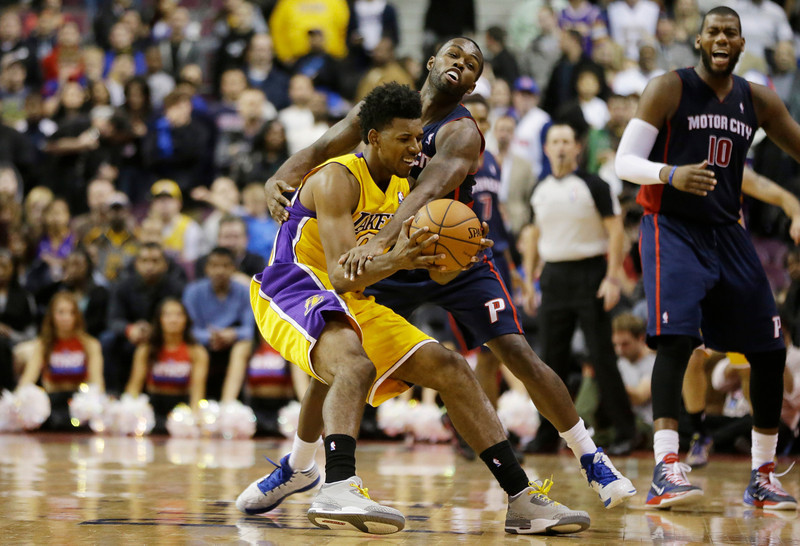 Detroit Pistons guard Rodney Stuckey reaches in and fouls Los Angeles Lakers  forward Nick Young (0) in the closing seconds of their NBA basketball game at the Palace in Auburn Hills, Mich., Friday, Nov. 29, 2013. (AP Photo/Carlos Osorio)