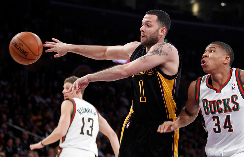 Los Angeles Lakers guard Jordan Farmar (1) passes the ball away from Milwaukee Bucks shooting guard Giannis Antetokounmpo (34), of Greece, defending during the first half of an NBA basketball game Tuesday, Dec. 31, 2013, in Los Angeles. (AP Photo/Alex Gallardo)