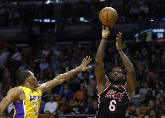 Miami Heat forward LeBron James (6) shoots for three points over Los Angeles Lakers forward Wesley Johnson (11) during the second quarter of an NBA basketball game in Miami, Thursday, Jan. 23, 2014. The Heat won 109-102. (AP Photo/Alan Diaz) 