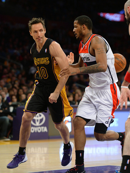 The Lakers' Steve Nash does a behind the back pass after driving the key on the Wizards' Trevor Ariza, Friday, March 21, 2014, at Staples Center. (Photo by Michael Owen Baker/L.A. Daily News)