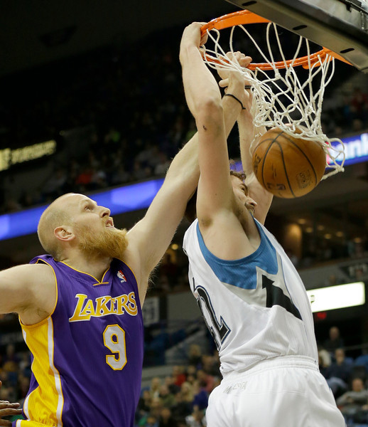 Minnesota Timberwolves forward Kevin Love, right, makes basket against Los Angeles Lakers center Chris Kaman (9) during the first quarter of an NBA basketball game in Minneapolis, Friday, March 28, 2014. The Timberwolves won 143-107. (AP Photo/Ann Heisenfelt)
