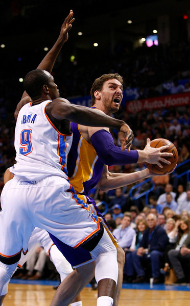 Oklahoma City Thunder forward Serge Ibaka (9) defends as Los Angeles Lakers center Pau Gasol (16) goes to the basket during the first quarter of an NBA basketball game in Oklahoma City, Thursday, March 1