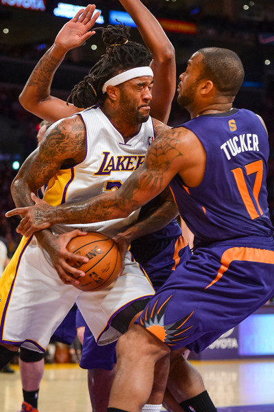Lakers' Jordan Hill is wrapped by by Suns P.J Tucker during first period action  at Staples Center Sunday, March 30, 2014.  ( Photo by David Crane/Los Angeles Daily News )