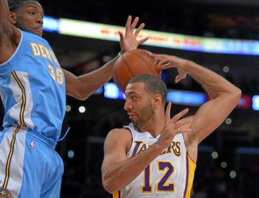 n this file photo, the Lakers' Kendall Marshall makes an errant pass behind his head as Nuggets' Kenneth Faried defends him under the basket at the Staple Center in Los Angeles, CA on Sunday, Jan. 5, 2014. (Photo by Scott Varley, Daily Breeze file) 