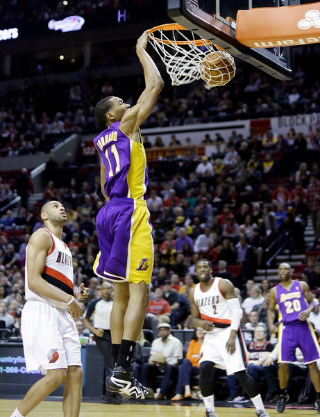 Los Angeles Lakers forward Wesley Johnson, right, scores on a fast break against Portland Trail Blazers forward Nicolas Batum, of France, during the first half of an NBA basketball game in Portland, Ore., Monday, March 3, 2014. (AP Photo/Don Ryan)