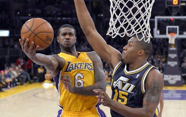 Los Angeles Lakers forward Earl Clark, left, puts up a shot as Utah Jazz forward Derrick Favors defends during the first half of an NBA basketball game, Friday, Jan. 25, 2013, in Los Angeles. (AP Photo/Mark J. Terrill)