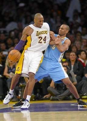 Los Angeles Lakers guard Kobe Bryant (24) battles Denver Nuggets guard Arron Afflalo (10) in the first half of an NBA basketball game, Sunday, Nov. 23, 2014, in Los Angeles. (AP Photo/Gus Ruelas) 