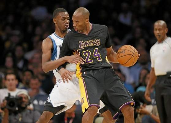 Minnesota Timberwolves' Andrew Wiggins defends against Los Angeles Lakers' Kobe Bryant during the first half of an NBA basketball game Friday, Nov. 28, 2014, in Los Angeles. (AP Photo/Danny Moloshok) 
