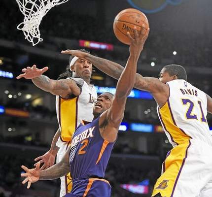 Phoenix Suns guard Eric Bledsoe, center, goes to the basket as Los Angeles Lakers center Jordan Hill, left, and forward Ed Davis defend during the second half of an NBA basketball game, Sunday, Dec. 28, 2014, in Los Angeles. The Suns won 116-107. (AP Photo/Mark J. Terrill) 