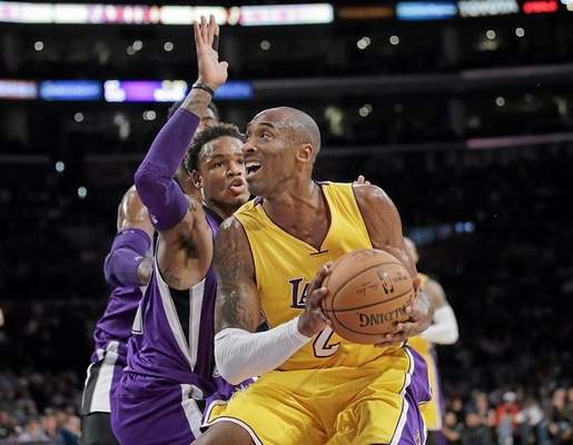 Los Angeles Lakers' Kobe Bryant, right, looks to shoot as he is pressured by Sacramento Kings' Ben McLemore during the first half of an NBA basketball game Tuesday, Dec. 9, 2014, in Los Angeles. (AP Photo/Jae C. Hong) 