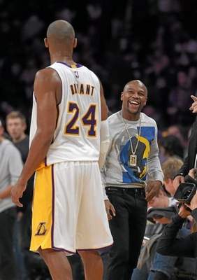 Los Angeles Lakers guard Kobe Bryant, left, talks with boxer Floyd Mayweather Jr. after the Lakers' NBA basketball game against the Phoenix Suns, Sunday, Dec. 28, 2014, in Los Angeles. The Suns won 116-107. (AP Photo/Mark J. Terrill) 