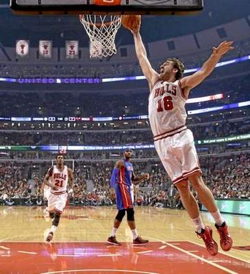 Chicago Bulls forward Pau Gasol goes in for the dunk as Jimmy Butler (21) and Andre Drummond (0) watch during the first half of an NBA basketball game against the Detroit Pistons Monday, Nov. 10, 2014, in Chicago. (AP Photo/Charles Rex Arbogast) 
