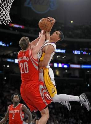 Los Angeles Lakers guard Jordan Clarkson, right, goes up for a shot as Houston Rockets forward Donatas Motiejunas, of Lithuania, defends during the first half of an NBA basketball game, Sunday, Jan. 25, 2015, in Los Angeles. (AP Photo/Mark J. Terrill) 