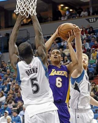 Los Angeles Lakersí Jordan Clarkson, center, shoots between Minnesota Timberwolvesí Gorgui Dieng, left, and Chase Budinger during the second half of an NBA basketball game, Wednesday, March 25, 2015, in Minneapolis. Clarkson led the Lakers with 20 points in their 101-99 overtime win. (AP Photo/Jim Mone) 