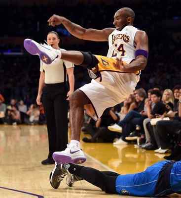 Kobe Bryant trips over Dallas’ Chandler Parsons during the first quarter at the Staples Center on Sunday. Stephen Carr — staff photographer
