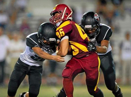 La Canada RB Ryan Breneman is tackled by Rio Hondo's Mikey Tsogt, left, and Domenico Chico, Thursday, Sept. 25, 2014, at La Canada. (Photo by Michael Owen Baker/Los Angeles Daily News) 