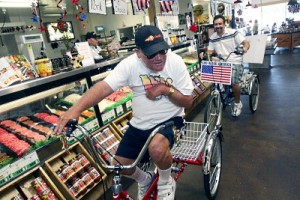 Dan Martin, 51, of Whittier, left, rides his new adult-sized tricycle with friend Troy Silva, inside Orchard's Fresh Foods, during Martin's 51st birthday celebration, at Orchard's Fresh Food Market in Whittier, Thursday, August 6, 2009. Dan Martin a professional motorcross rider in the seventies, was injured and is now partially paralyzed. Martin rides his bike everyday to Orchard's Fresh Foods. The owners of Orchard's Fresh Foods helped raise money to buy a new bike for Martin's for his 51st birthday. (Correspondent photo by James Carbone/SWCITY)