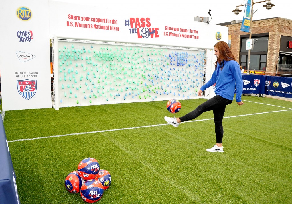 USWNT soccer star Alex Morgan kicked off a campaign dubbed #passthelove Friday in Hermosa Beach. Morgan and soccer players "painted" a mural by kicking a soccer ball at a blank canvas. The campaign bursts of paint. The interactive mural helped bring to life the new campaign, which is rallying fans to share their messages of support with the team on Twitter using the hashtag #PASSTHELOVE.