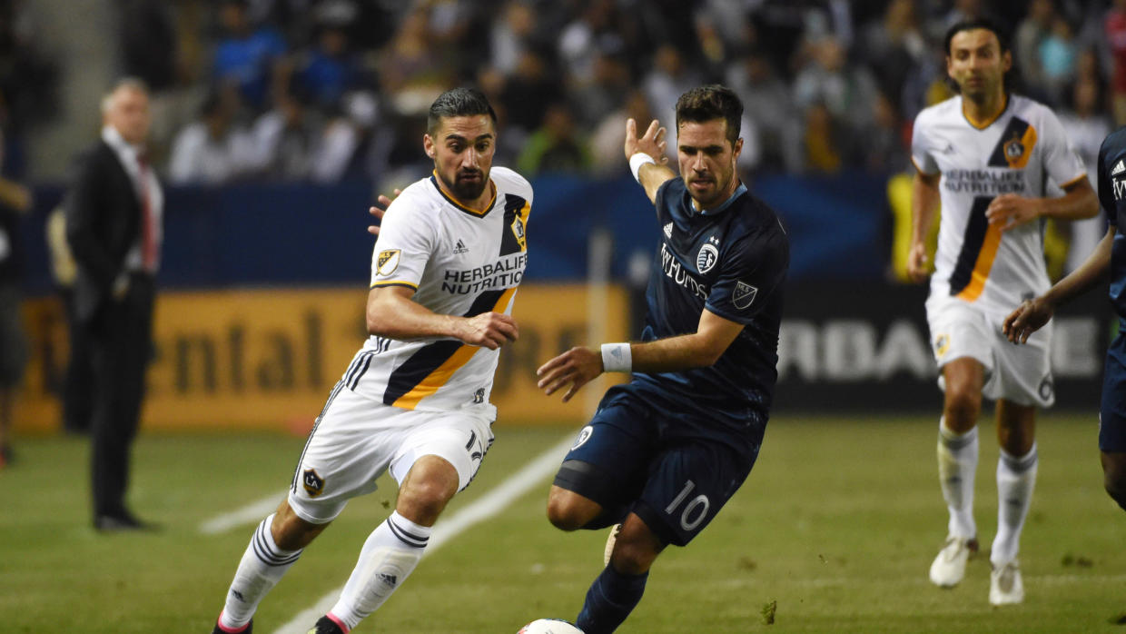 L.A. Galaxy's Sebastian Lletget battles for possession against Sporting Kansas City's Benny Feilhaber. (USA TODAY Images)