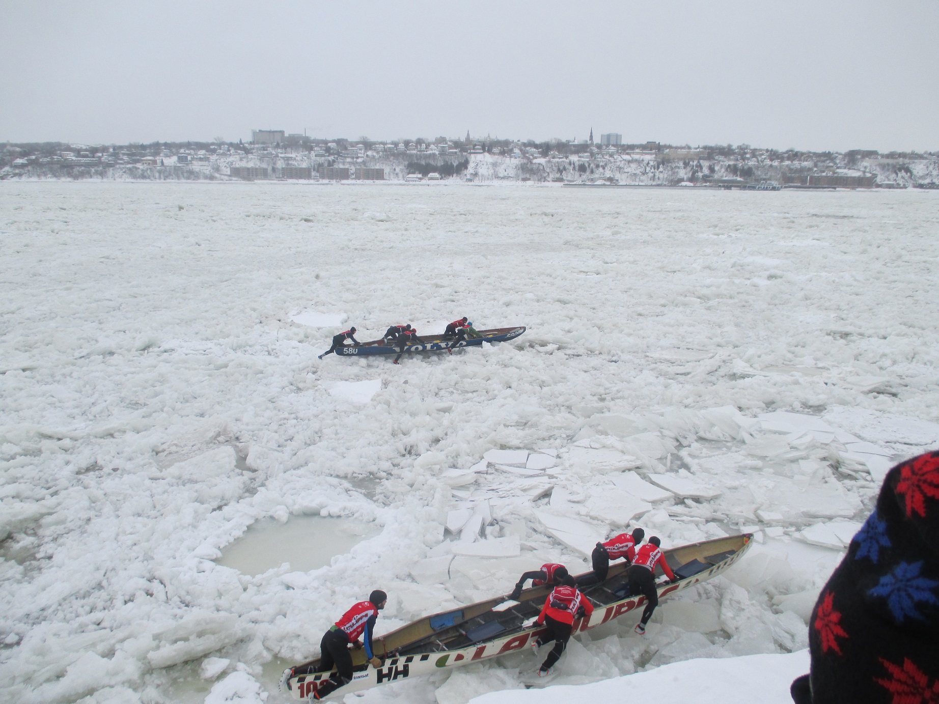 Two crews  in the elite male class compete in the ice canoe race on the St. Lawrence River. (Photo by Marlene Greer) 