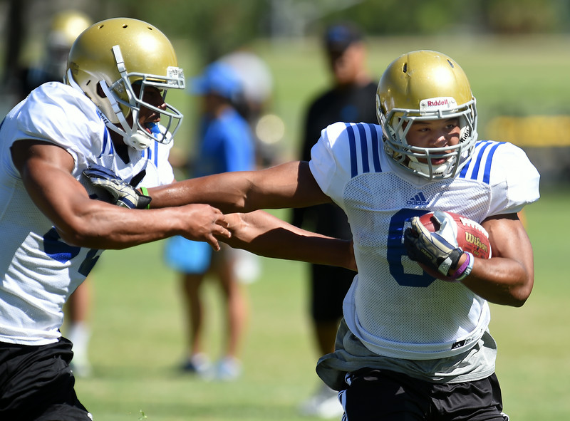 RB Jordon James, right, carries the ball during the UCLA practice at Cal State San Bernardino. Wednesday, August 6, 2014. (Jennifer Cappuccio Maher/Daily Bulletin)"