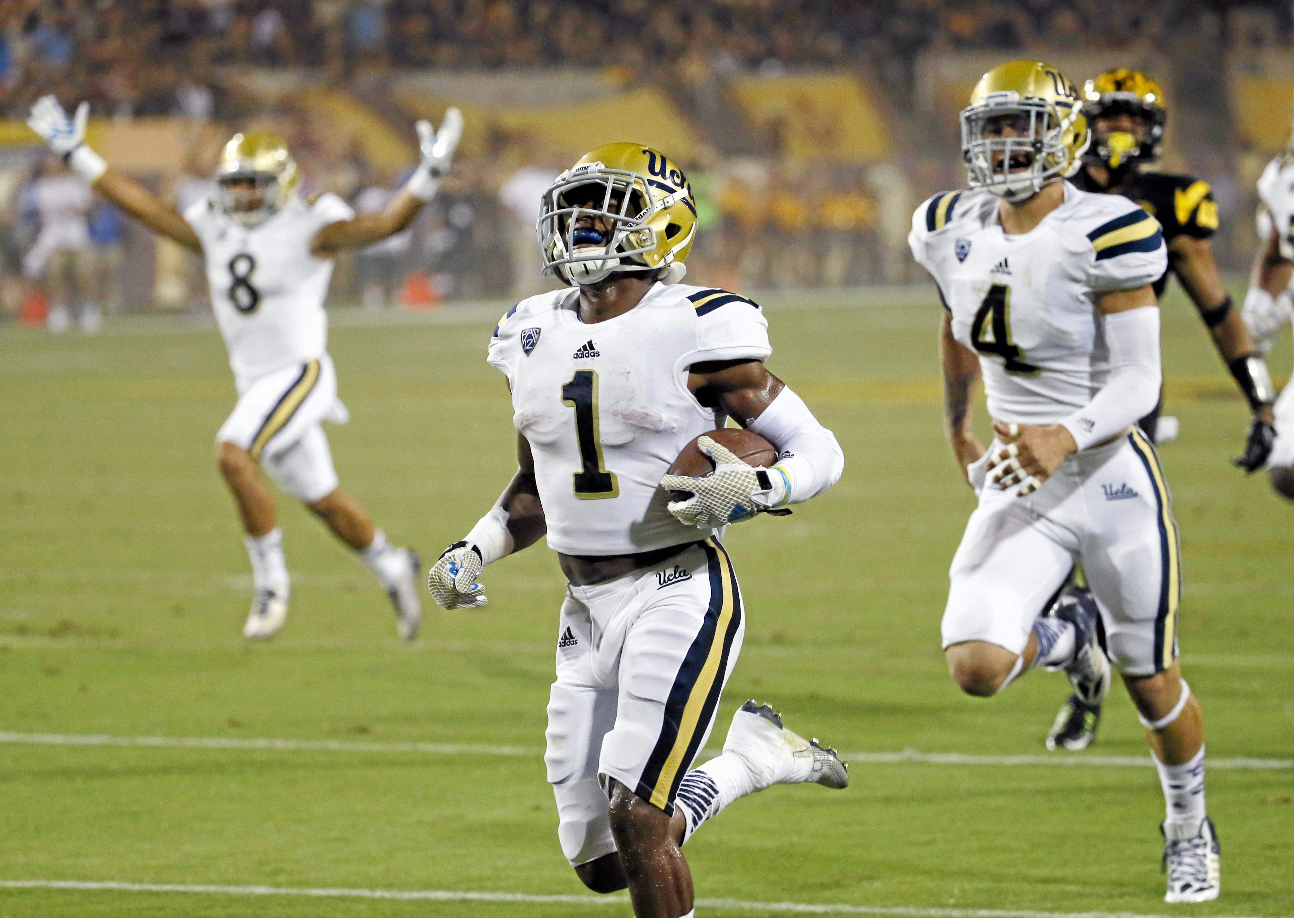 UCLA's Ishmael Adams (1) returns a kickoff 100 yards for a touchdown against Arizona State during the second half of an NCAA college football game, Thursday, Sept. 25, 2014, in Tempe, Ariz. (AP Photo/Matt York) 