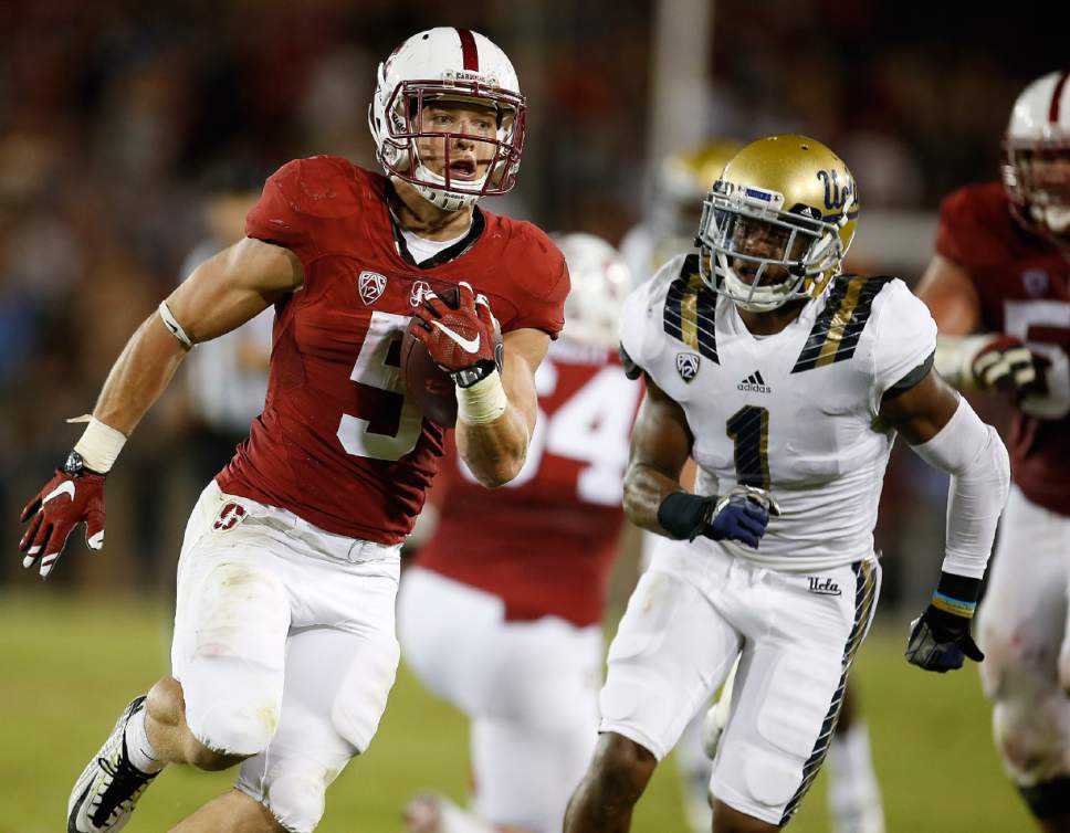 Stanford running back Christian McCaffrey (5) runs past UCLA defensive back Ishmael Adams (1) for a touchdown during the first half of an NCAA college football game Thursday, Oct. 15, 2015, Stanford, Calif. (AP Photo/Tony Avelar)