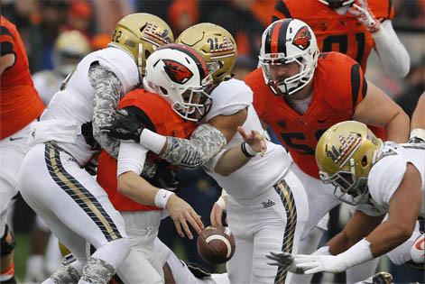 Oregon State quarterback Nick Mitchell fumbles the ball while being tackled by a pair of UCLA defenders in the first half of an NCAA football game, in Corvallis, Ore., on Saturday, Nov. 7, 2015. (AP Photo/Timothy J. Gonzalez)