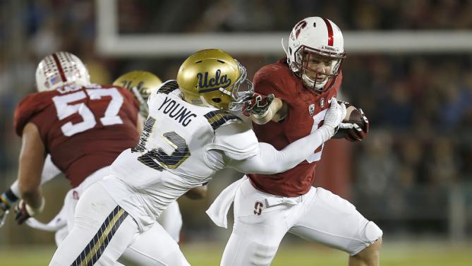 Stanford running back Christian McCaffrey (5) stiff-arms UCLA linebacker Kenny Young (42) during the first half of an NCAA college football game Thursday, Oct. 15, 2015, Stanford, Calif. (AP Photo/Tony Avelar)