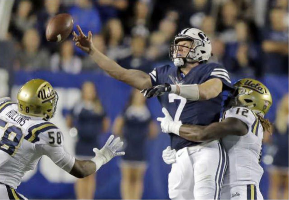 UCLA linebacker Jayon Brown (12) hits BYU quarterback Taysom Hill (7) as he throws during the first half of an NCAA college football game Saturday, Sept. 17, 2016, in Provo, Utah. (AP Photo/Rick Bowmer)