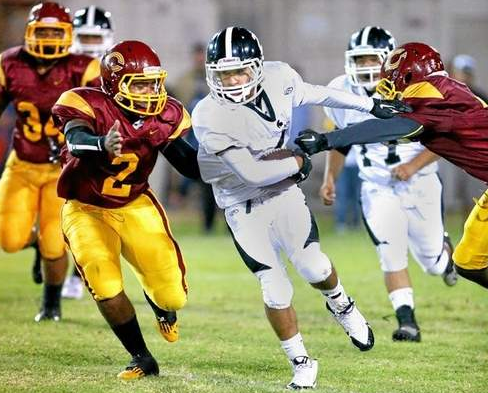 Darion Lindsey and Jojo Turner of Cantwell-Sacred Heart trap Pioneer running back Jakob Williams for a small gain in the first half of prep football action Friday September 26, 2014 at Cantwell. (Correspondent photo by Chris Burt/Sports) 