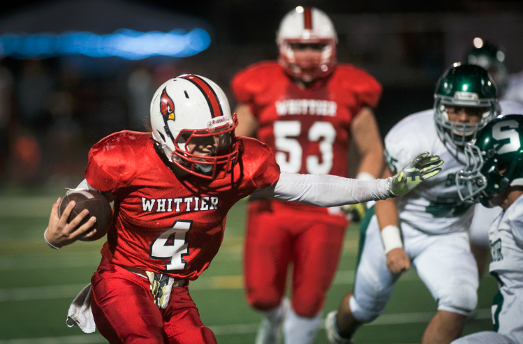 Whittier High School Cardinals quarterback Dylan Salcido runs the ball up against Schurr High School Spartans defenders in the first half during a matchup at Sandy Thorstenson Stadium in Whittier. (Photo by Michael Ares)